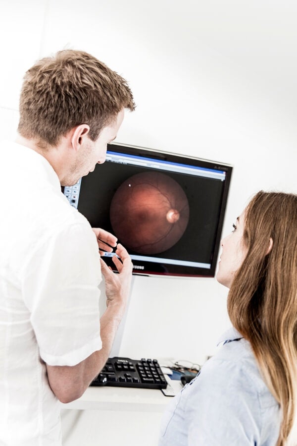 Optiker forklarer resultat av synstest til kvinnelig pasient