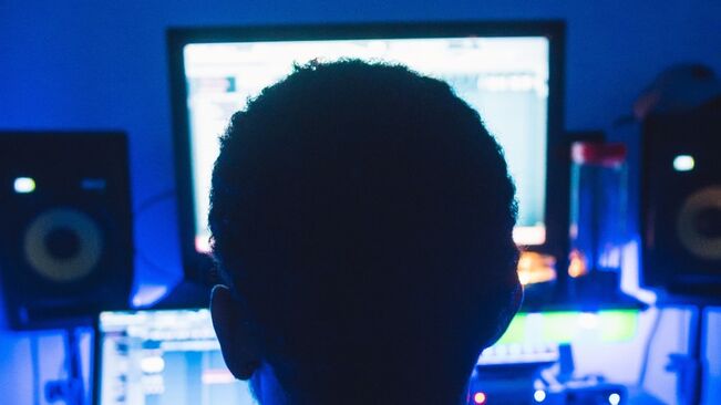Person foran datamaskin med blått lys fra skjermen
