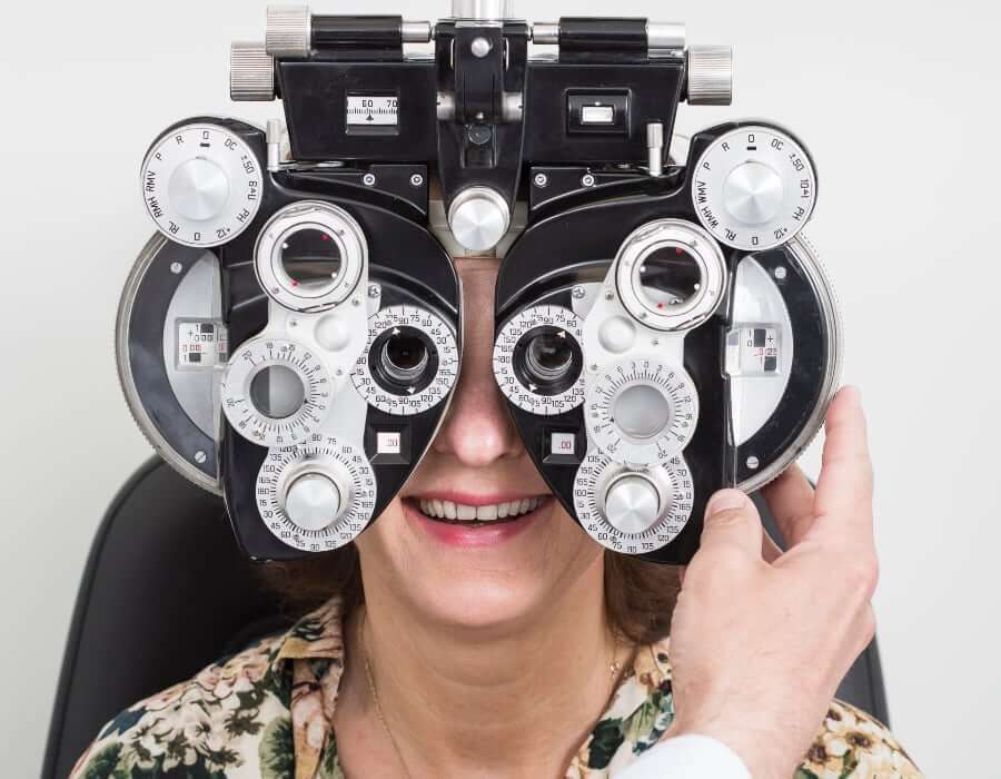 Dame som får målt synet med instrument for synstest