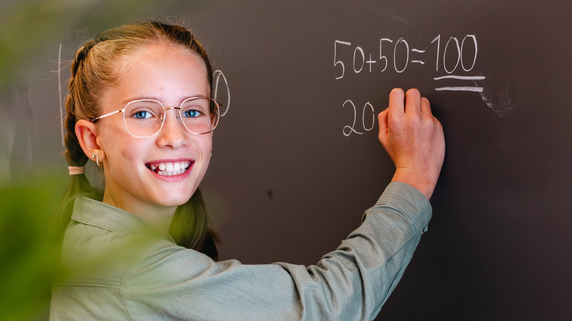 Jente som skriver regnestykker på tavla